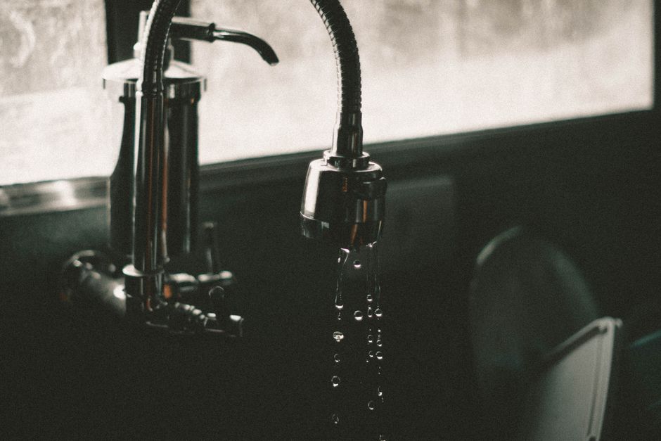 Close-up of a homeowner inspecting a kitchen sink drain for blockages